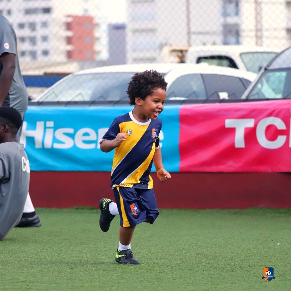 Bright Academy player smiling while running during a match