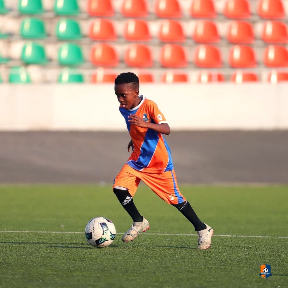 Bright Academy player dribbling the ball on the stadium pitch