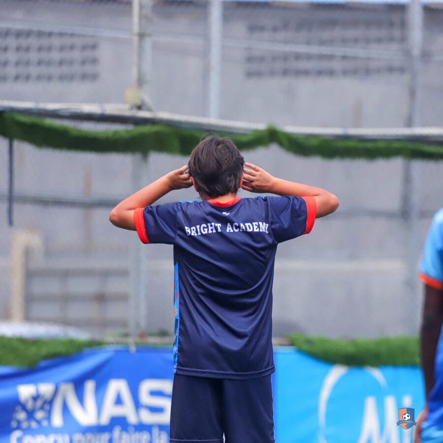 Bright Academy player wearing the club jersey, seen from behind