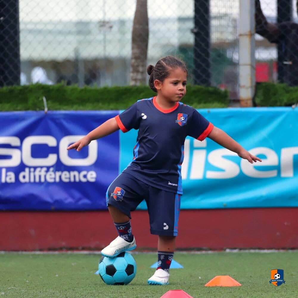 Young Bright Academy player working on ball control through cones